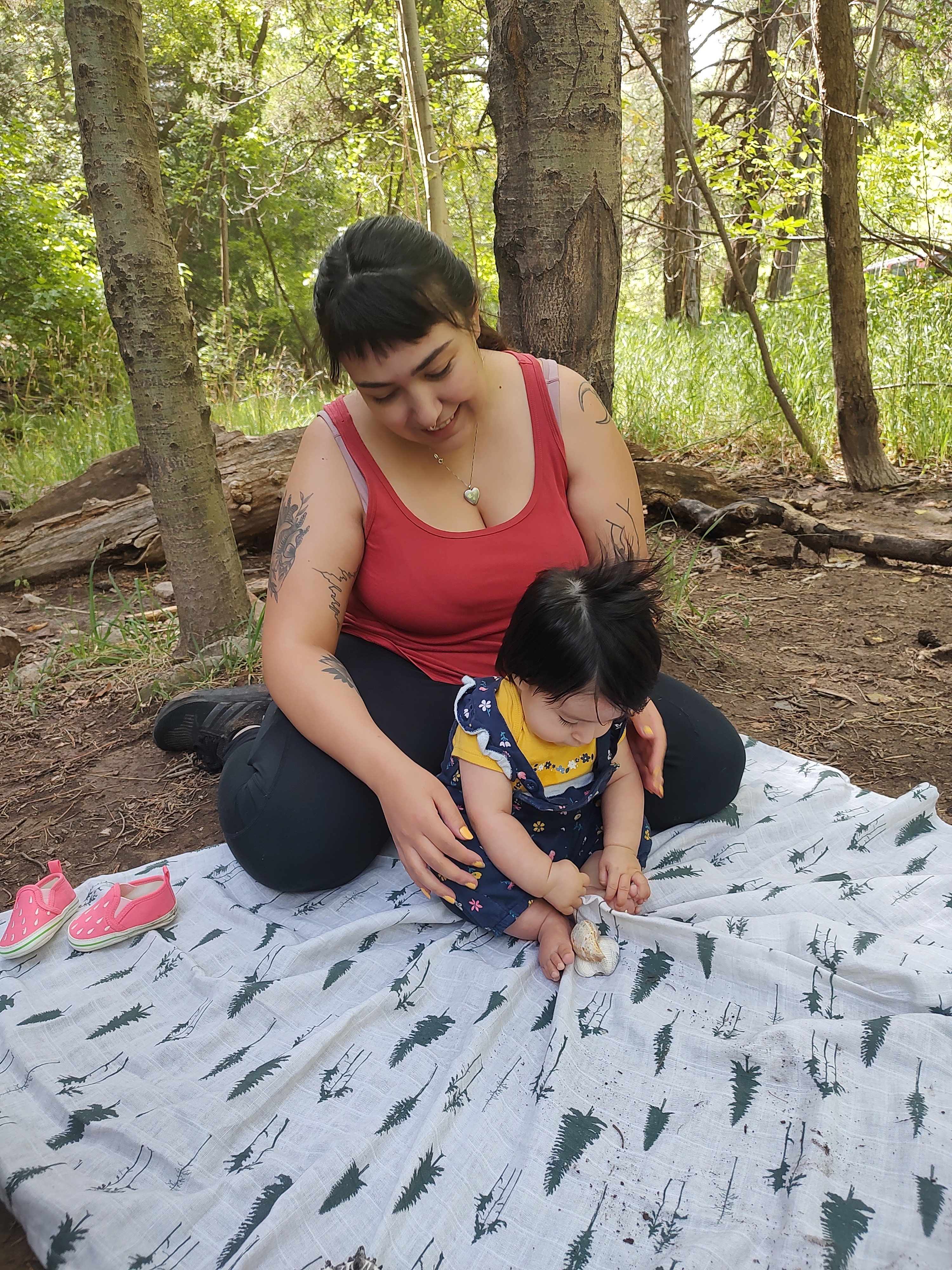 baby and mother sitting on a blanket together